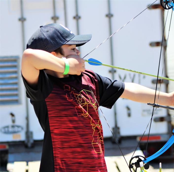 A boy learns how to shoot an arrow with a bow Saturday from archery experts.
