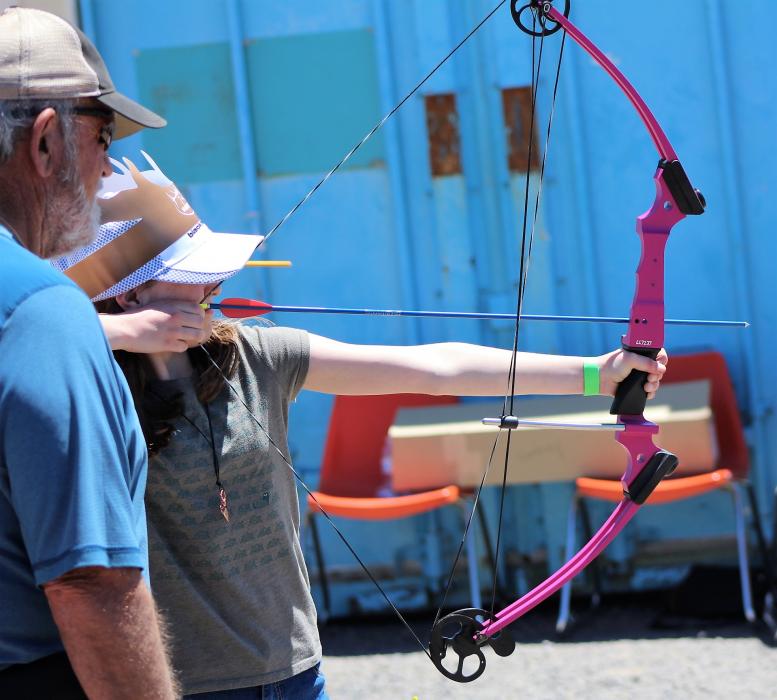 A girl learns archery from an expert Saturday at the Nevada Outdoor Experience.