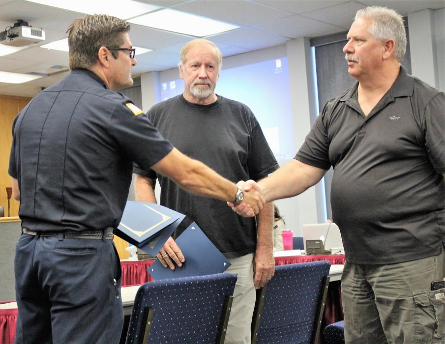 Carson City Fire Chief Sean Slamon shakes Dennis Manning's hand.