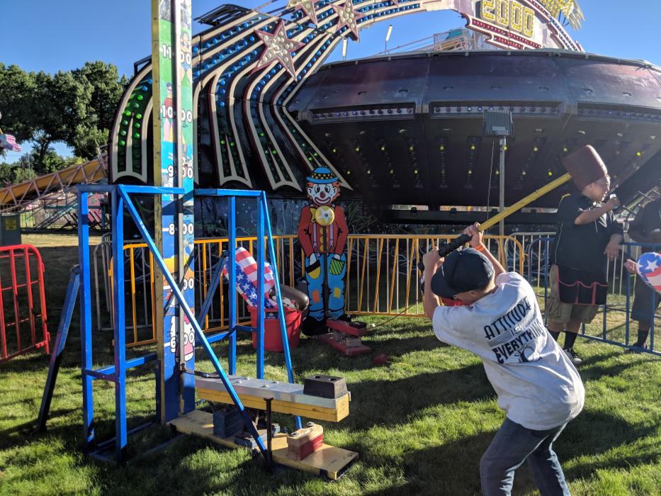 A boy swings a mallet at a midway game Saturday.