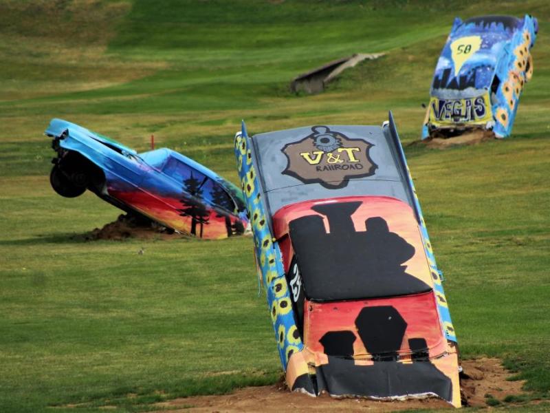 Photos by Brett Fisher. Half buried antique Cadillacs are features of the Silver Oak driving range.
