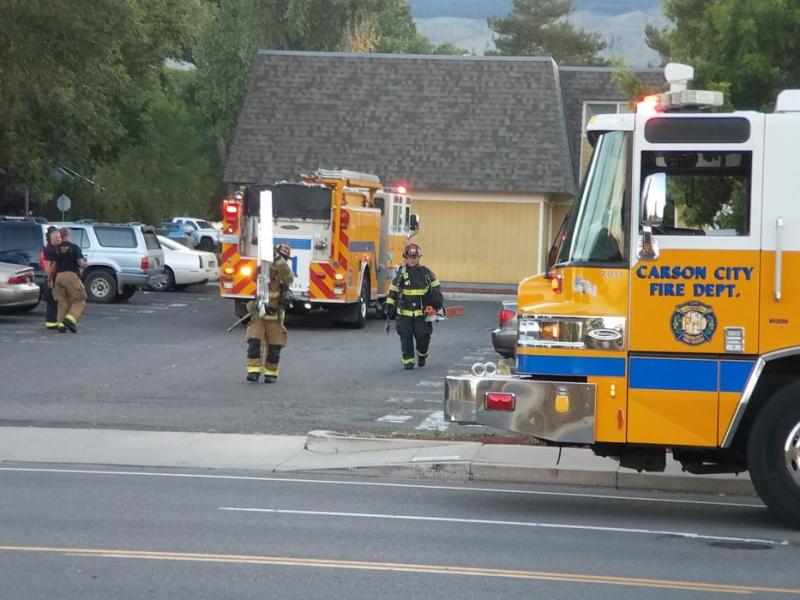 Photo by Brett Fisher. Firefighters carry ladders back to their engine Sunday evening at Carson Sunset Apartments.
