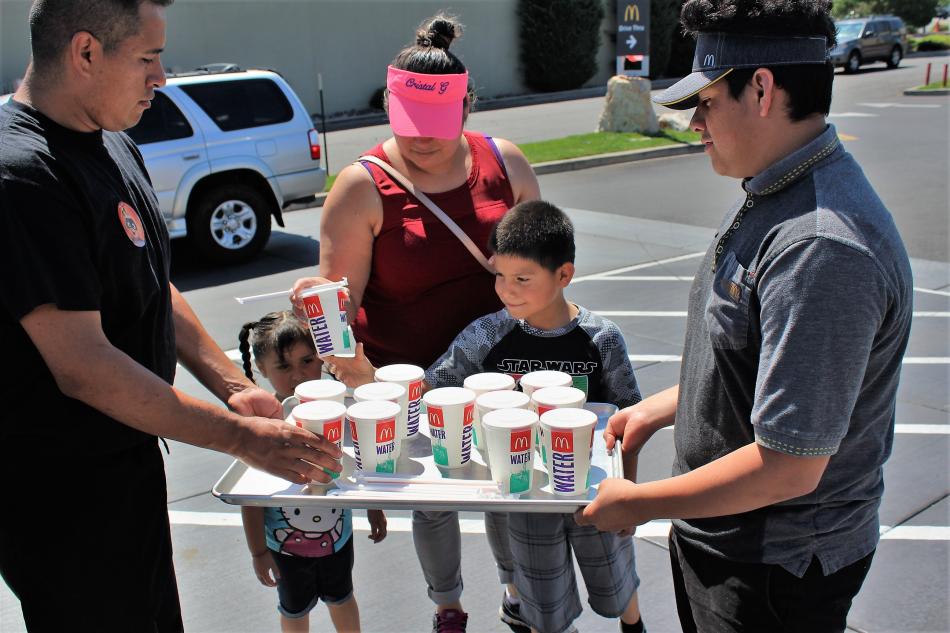McDonald's staff pass out cold water to guests waiting in line Saturday morning.