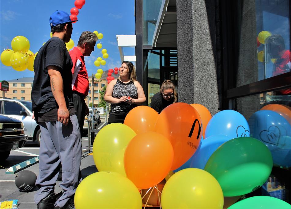 Staff decorate the outside of McDonald's with balloons.