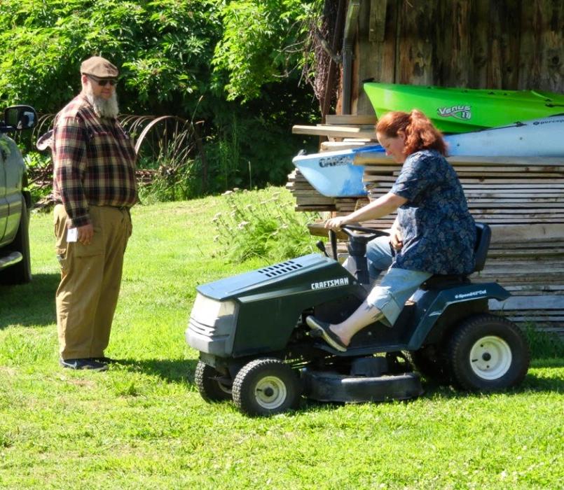 Shane watching Kelly trying to start the grass cutter.
