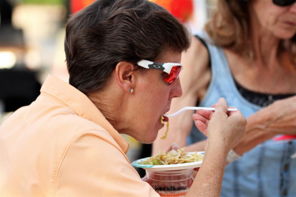 A woman eats Asian noodles Saturday during the Taste of Downtown.
