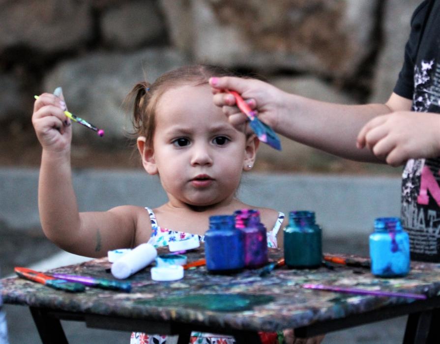 A little girl adds paint to her brush Saturday at the BAC.