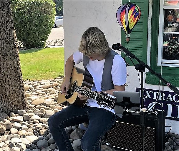 Photo by Arianna Schmidt. Mylo McCormick plays in front of the Purple Avocado Saturday.