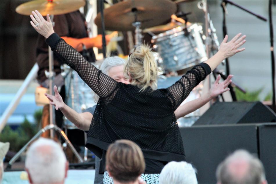 Photo by Brett Fisher. To women hug in front of the Minnesota Street Stage during the Trippin' King Snakes opening act.