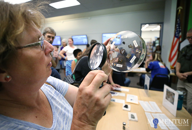 Shawn Wells looks at meteorite samples during the Carson City Library NASA event. Cathleen Allison, Nevada Momentum