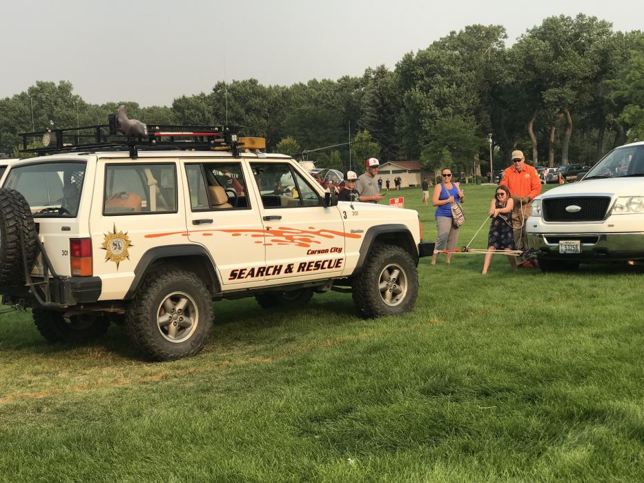 A young girl with obvious super strength hauls a Search and Rescue Jeep with her bare hands.