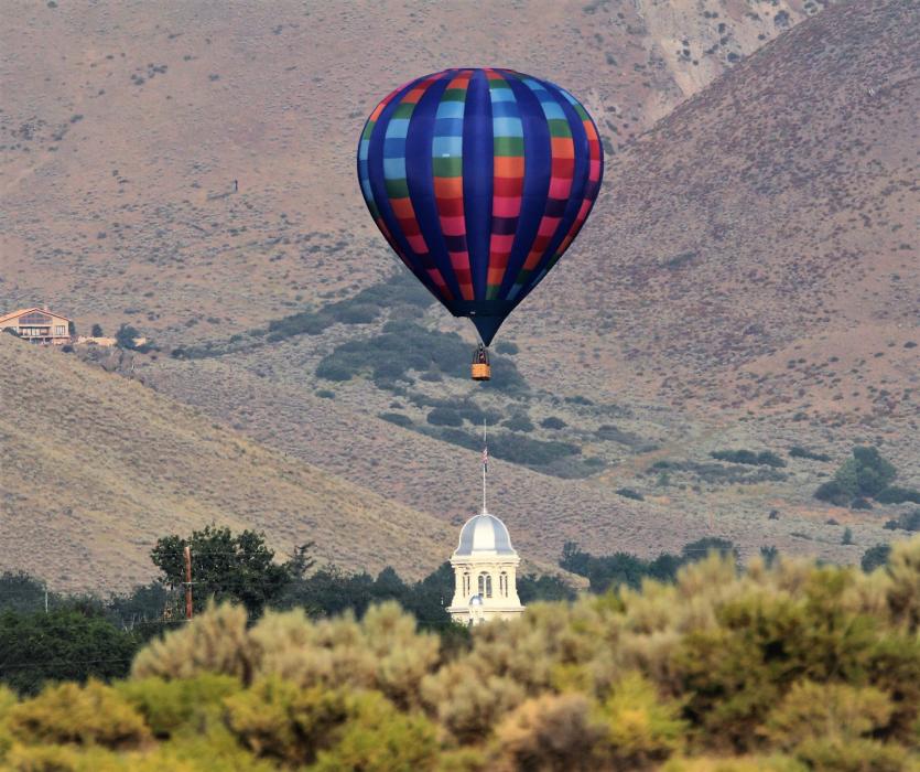 A hot air balloon floats directly over the Nevada Capitol Saturday morning.