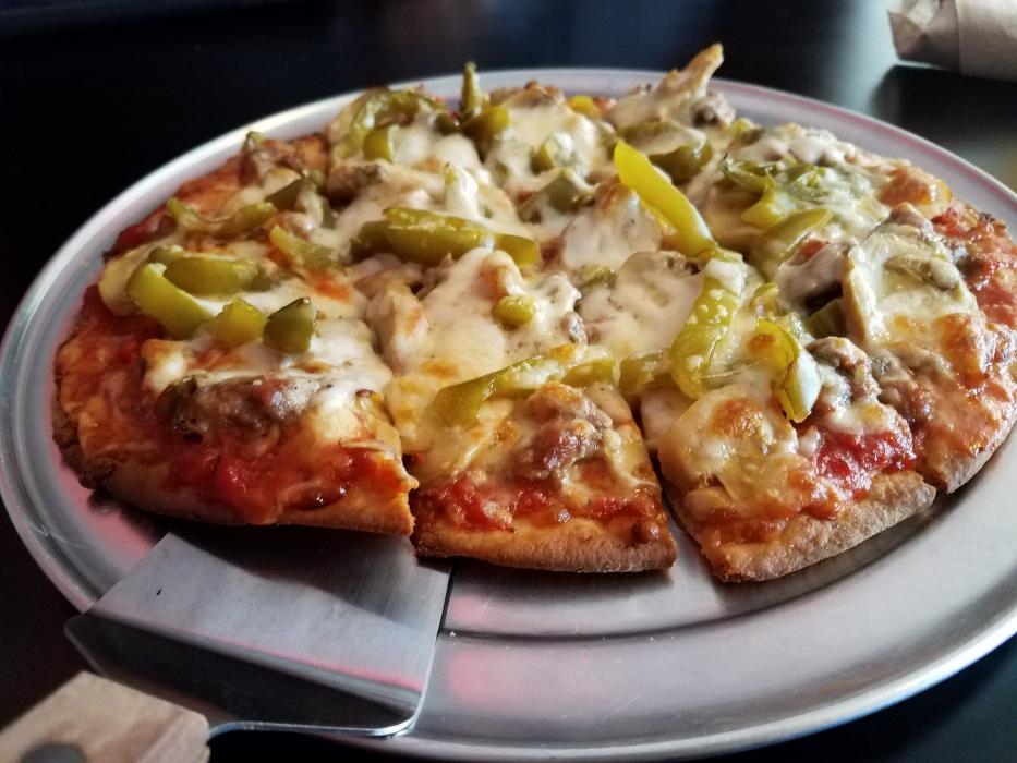 Thin crust pizza featuring Italian sausage, mushrooms and peppers.