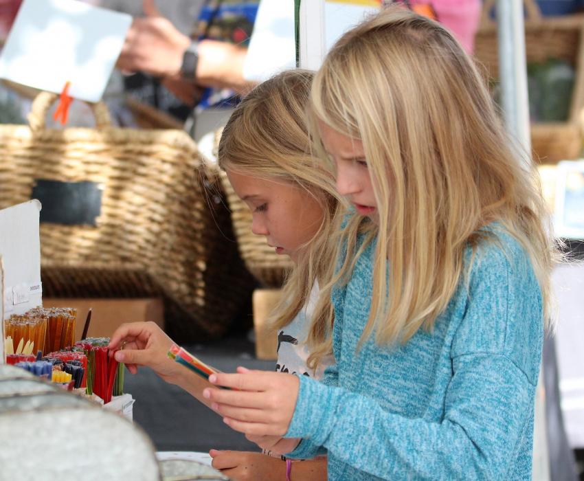 Girls select honey sticks at a local raw honey vendor booth Saturday.