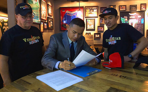 Reno’s Ricardo “The Dreamer” Lucio-Galvan is flanked by Bill Nelson, left, and Marvin Simeon as he inks a four-year deal.