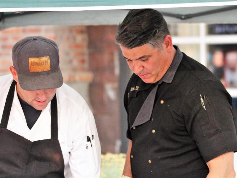 Photo by Brett Fisher. The Union owner and Chef Mark Estee (right) prepares eats during the 2018 Taste of Downtown.