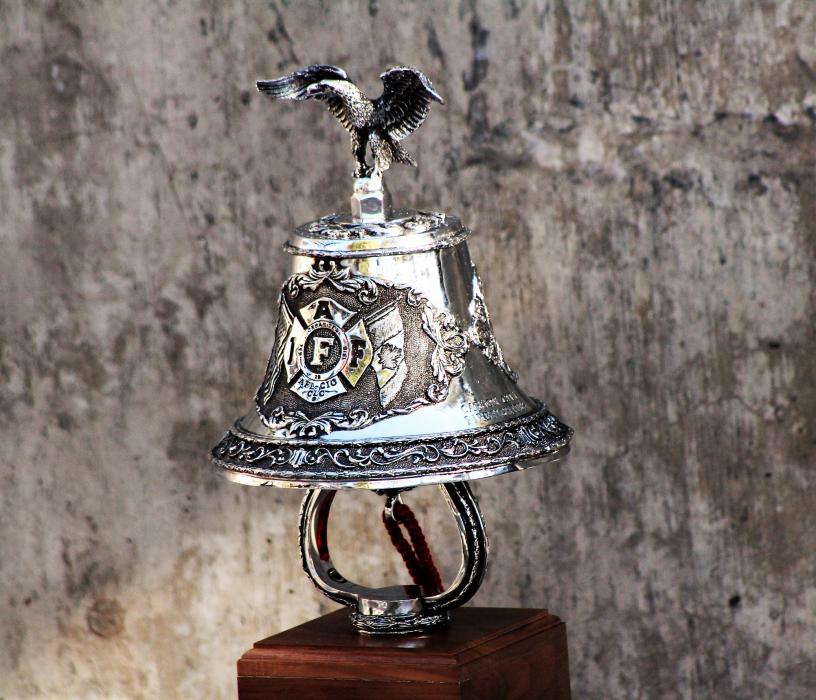 The ceremonial bell is rung for each name on the memorial wall.