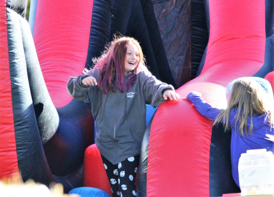 A girl has fun sliding down a bouncing inflatable Saturday.