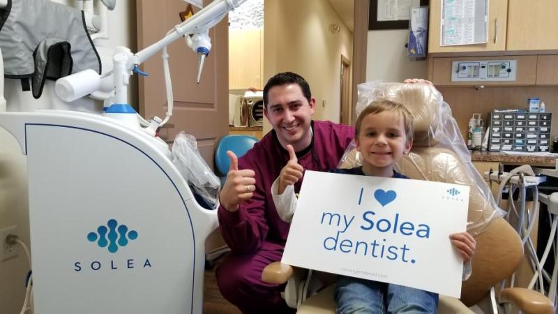 Kevin Olson, DMD, and co-owner of Carson City Pediatric Dentistry, with his patient, Mason after a successful dental procedure.