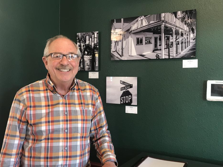 Owner John Arant stands beside the photos of the original Martin Hotel in Winnemucca