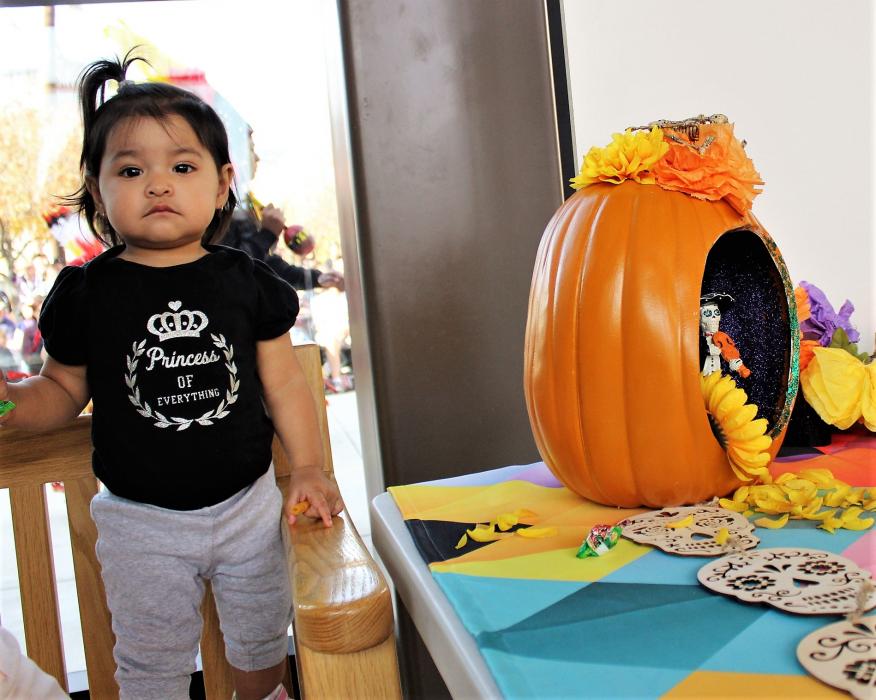 A small child stands next to an altar inside the Nevada State Museum Dema Guinn Concourse.