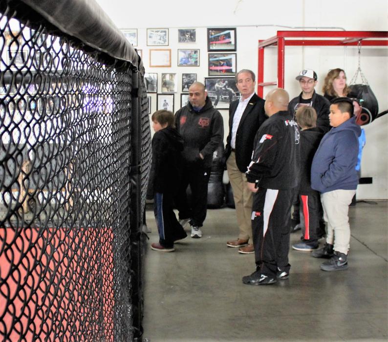 Cisco Rodriguez leads guests on a tour of the competitive training gym, including an MMA cage.