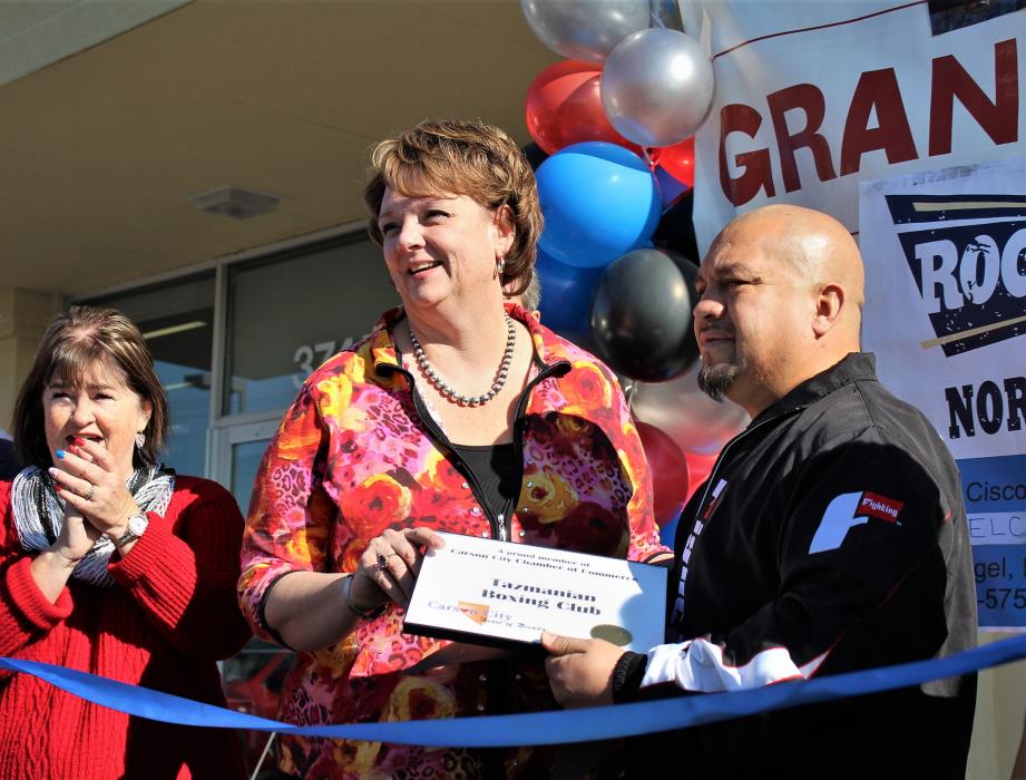 Lisa Lee of the Carson City Chamber of Commerce presents Cisco Rodriguez with a certificate.