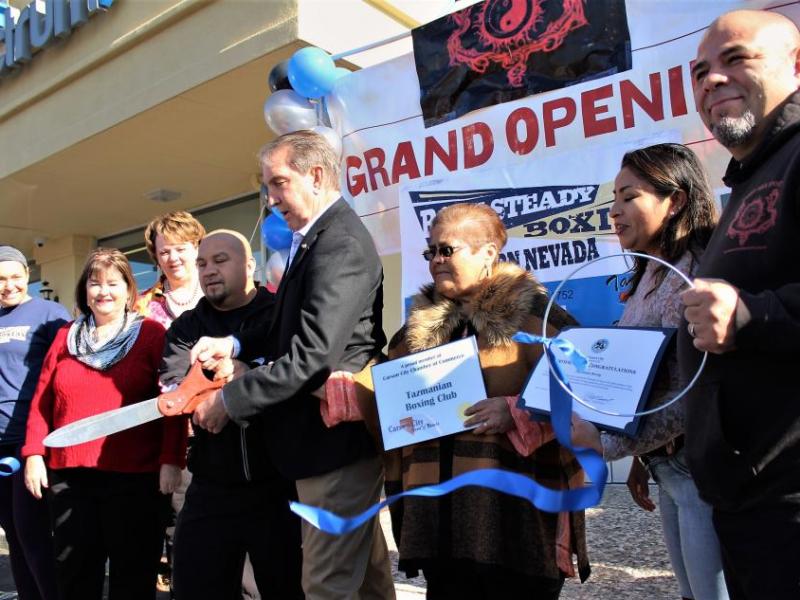 Photos by Brett Fisher. Holding giant scissors, Cisco Rodriguez and Carson City Mayor Bob Crowell cut the ribbon Saturday.