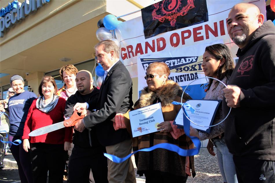 Photos by Brett Fisher. Holding giant scissors, Cisco Rodriguez and Carson City Mayor Bob Crowell cut the ribbon Saturday.