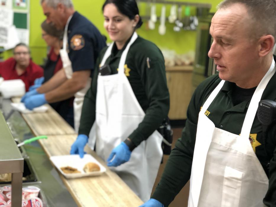 School Resource Officers Dean Williams and Liz Lopez serve breakfast to grade schoolers.