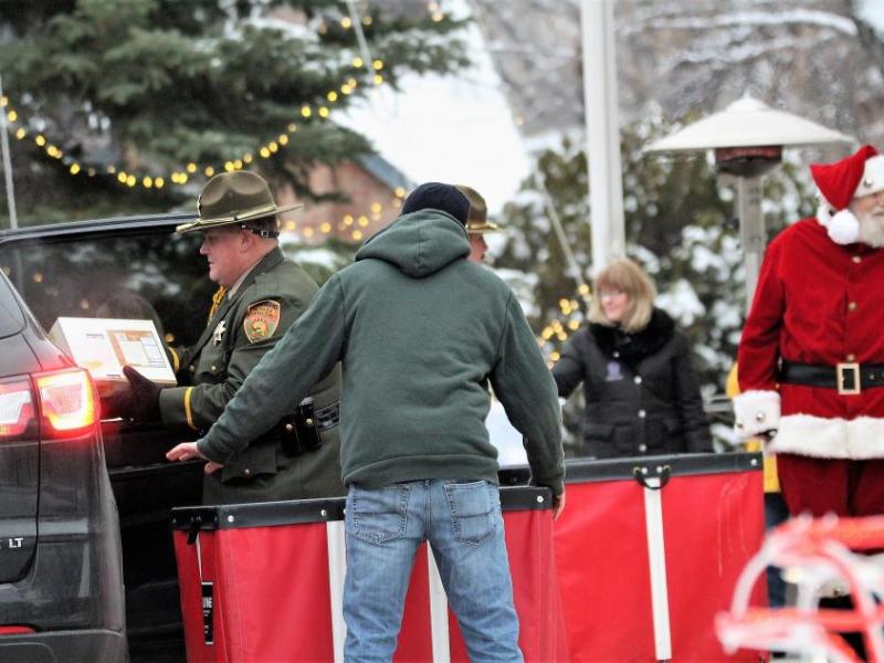 Photos by Brett Fisher. Santa Claus (right) looks on as a Nevada Dept. of Corrections Honor Guard member unloads donations.