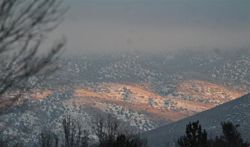 A patch of sunshine illuminates foothills of the Pine Nut Range nestled behind Prison Hill.