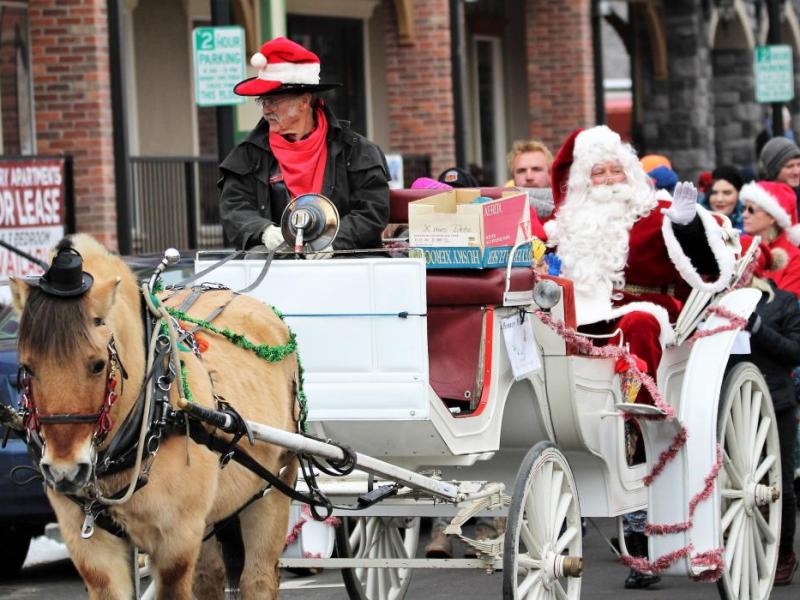 Photos by Brett Fisher. Santa Claus spreads Christmas cheer from a horse-drawn carriage.