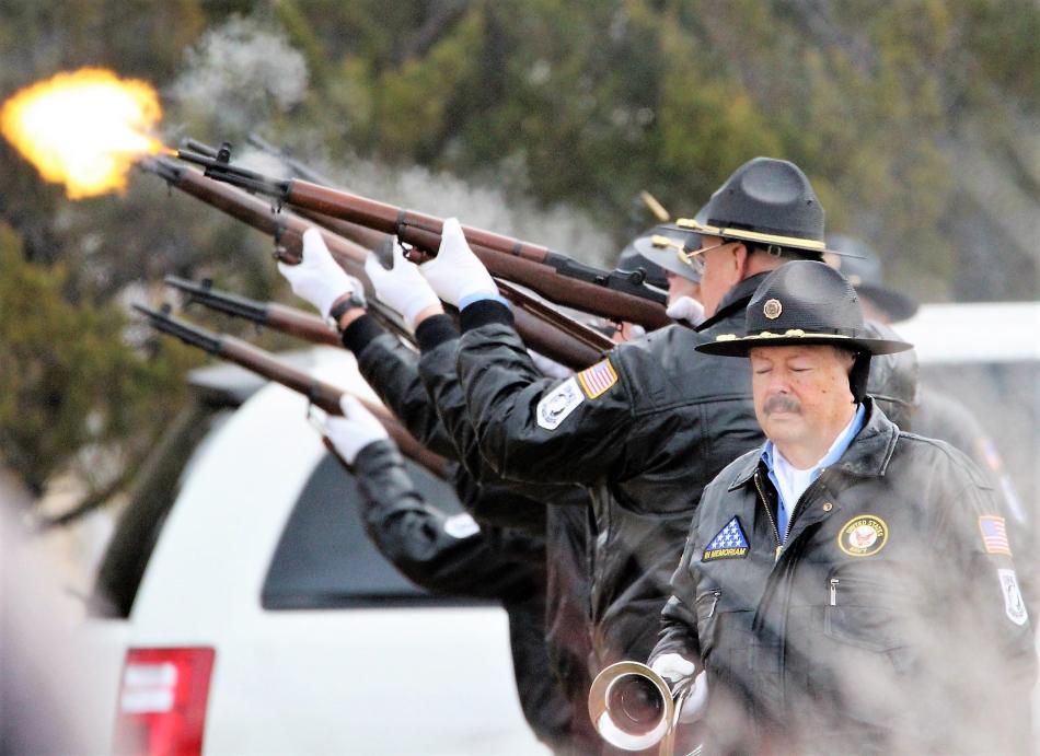 Photos by Brett Fisher. Honor guard members fire off a 21-gun salute during the 