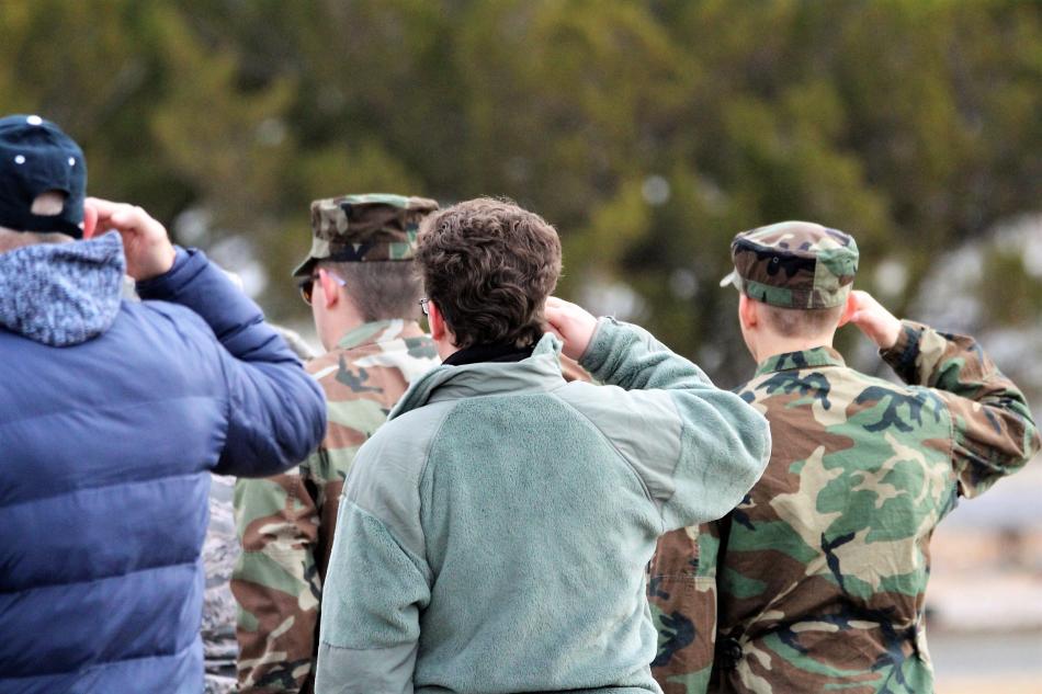 Active duty military and veterans salute during the playing of Taps at Lone Mountain Cemetery Saturday morning.