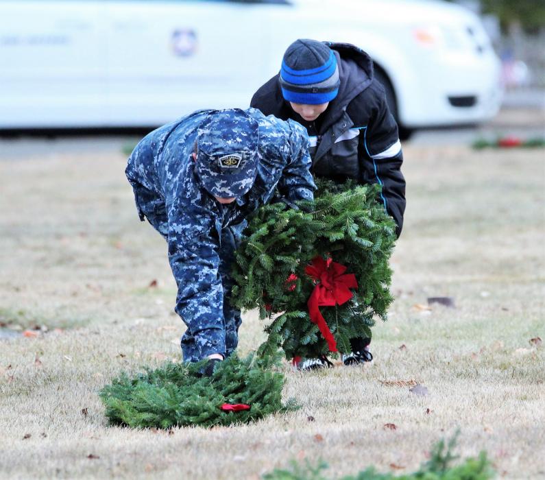 Volunteers lay Christmas wreaths Saturday morning at Lone Mountain Cemetery.