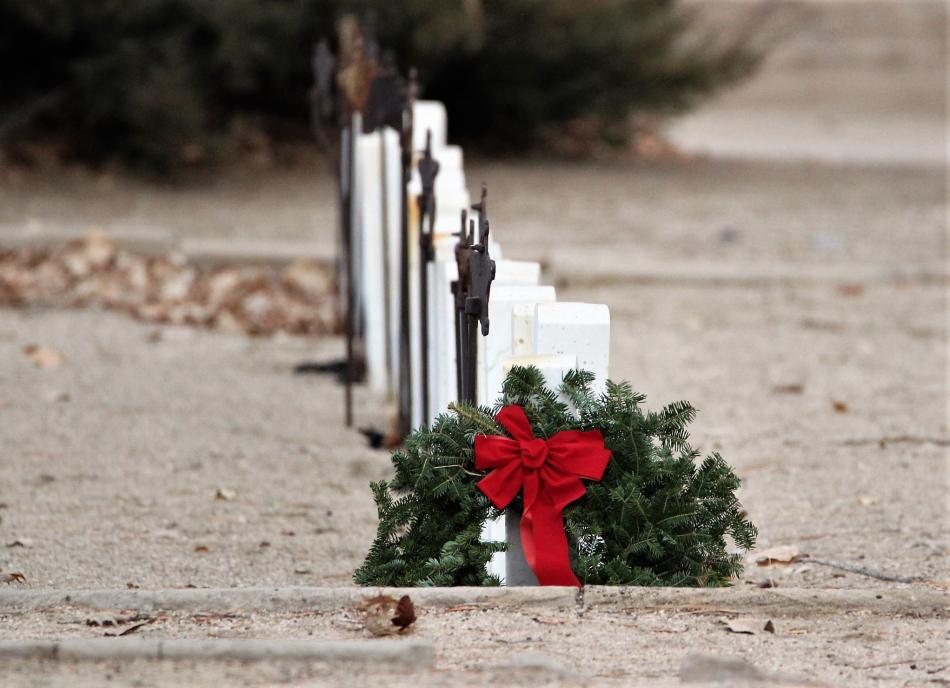 A Christmas wreath is laid at the head of a row of Nevada Civil War veterans.