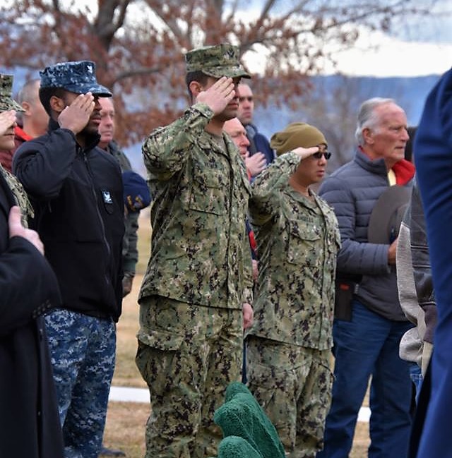 Active duty military salute during the playing of Taps.