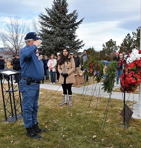 A veteran salutes the Christmas wreath for fallen brethren.