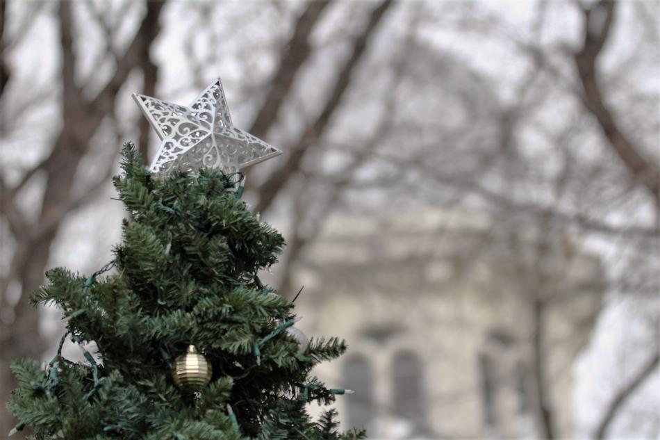 The atop a Christmas tree in the foreground of the State Capitol dome.