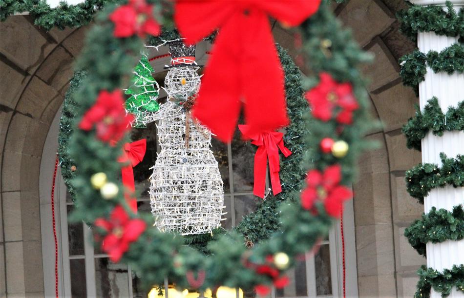A snowman decoration above the Capitol's front entrance, framed by a wreath.