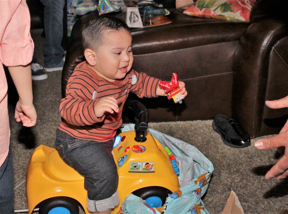 A small child enjoys riding on his gift from Santa Claus Monday night.