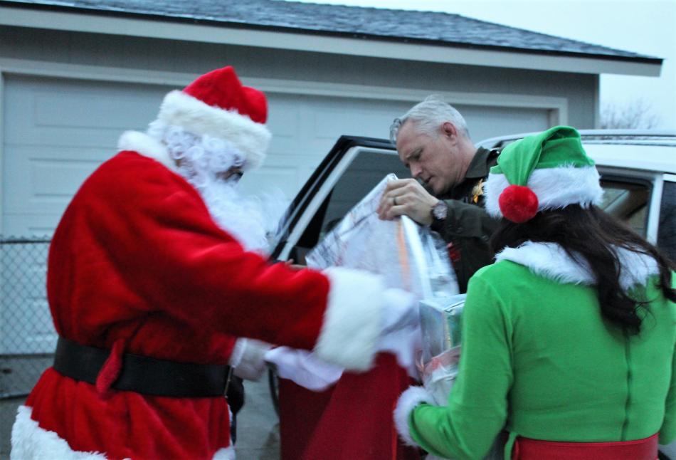 Santa, Carson City Sheriff's deputy Ken Perotti, and elf Kelley Perotti loads Santa's sack with gifts.