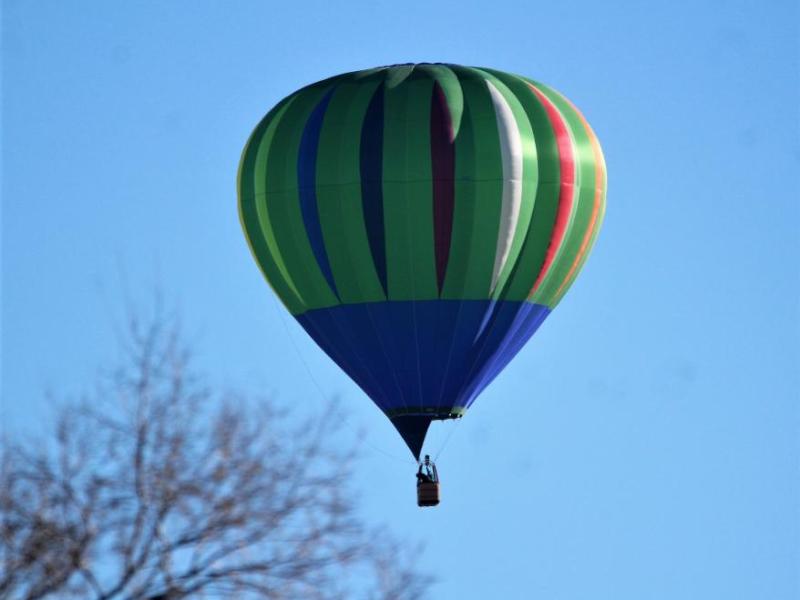 Photos by Brett Fisher. A hot air balloon descends from the sky over central Carson City Saturday morning.
