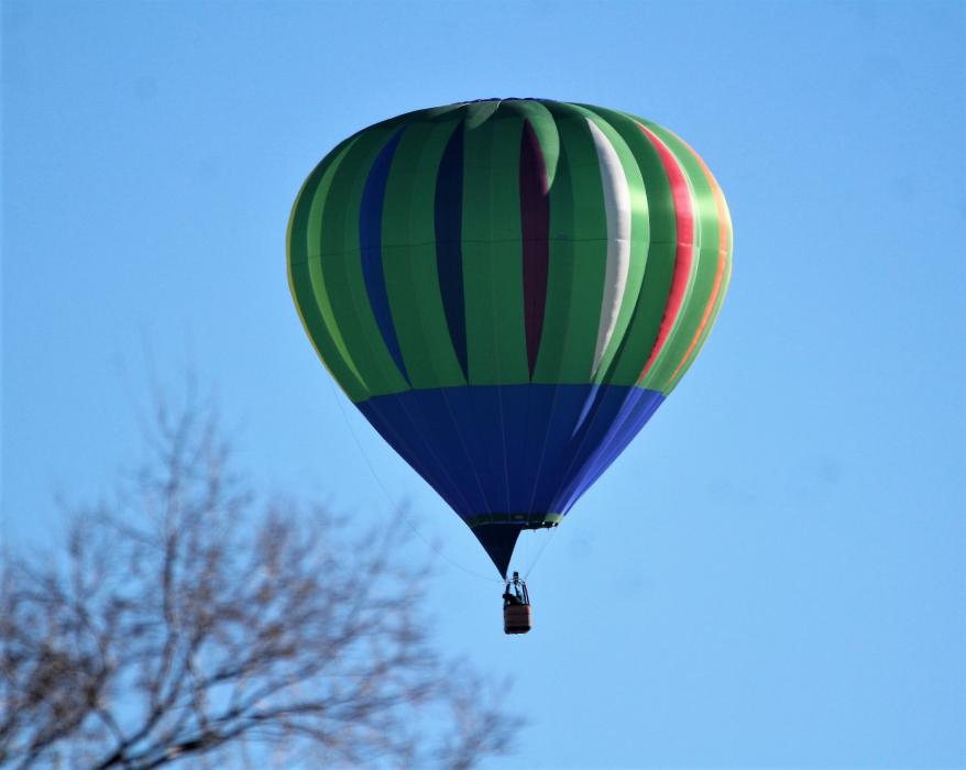 Photos by Brett Fisher. A hot air balloon descends from the sky over central Carson City Saturday morning.