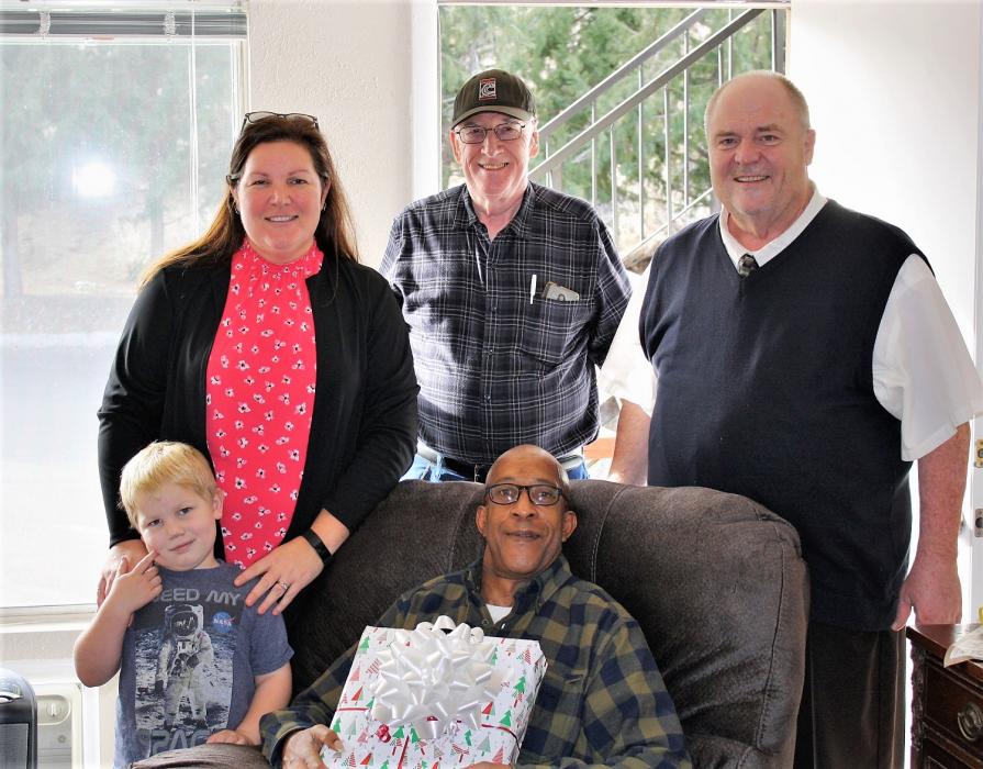 Robert Price of Carson City enjoys his new easy chair with Courtney and Andrew Warner, Jim Crowley and Warren Bottino.