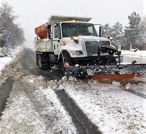 A Carson City snow plow clears snow from a city street.