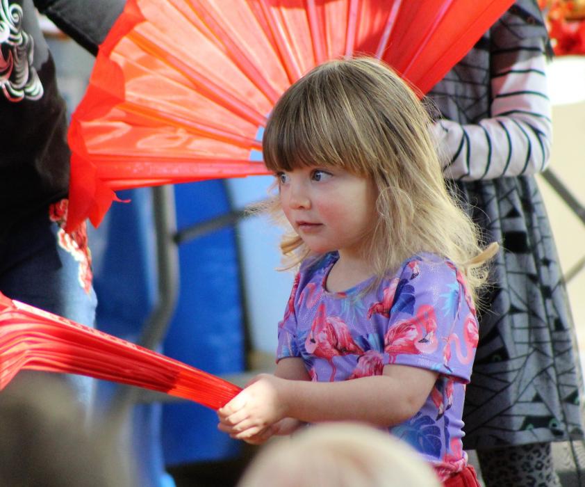 A girl learns how to use a Chinese fan Saturday at the Nevada State Museum.