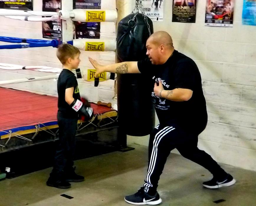 Cisco Rodriguez works with a youth on his boxing skills.