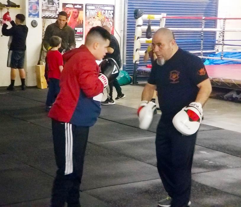 Juan Torres instructs a young man on proper punching techniques.